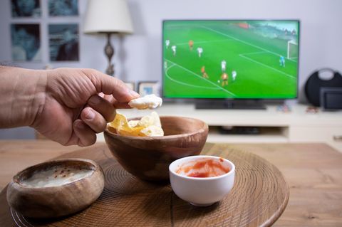 Fußball Snacks: Chips und Dipp auf einem runden braunen Tisch