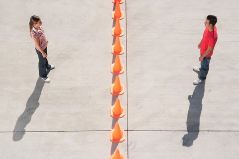Zwei Menschen stehen entfernt voneinander auf einem Betonboden. Vielleicht leiden sie unter Bindungsangst