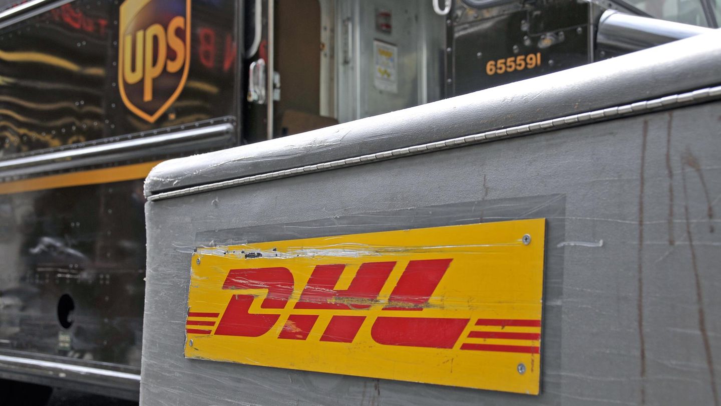 DHL Schild zerkratzt vor einem UPS-Paketshop