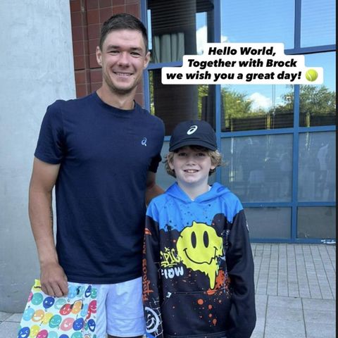 tennis-Spieler Kamil Majchrzak mit seinem jungen Fan Brock auf dem Gelände der US Open