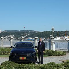 Der türkische Präsident Erdogan steht neben einem Auto von Togg