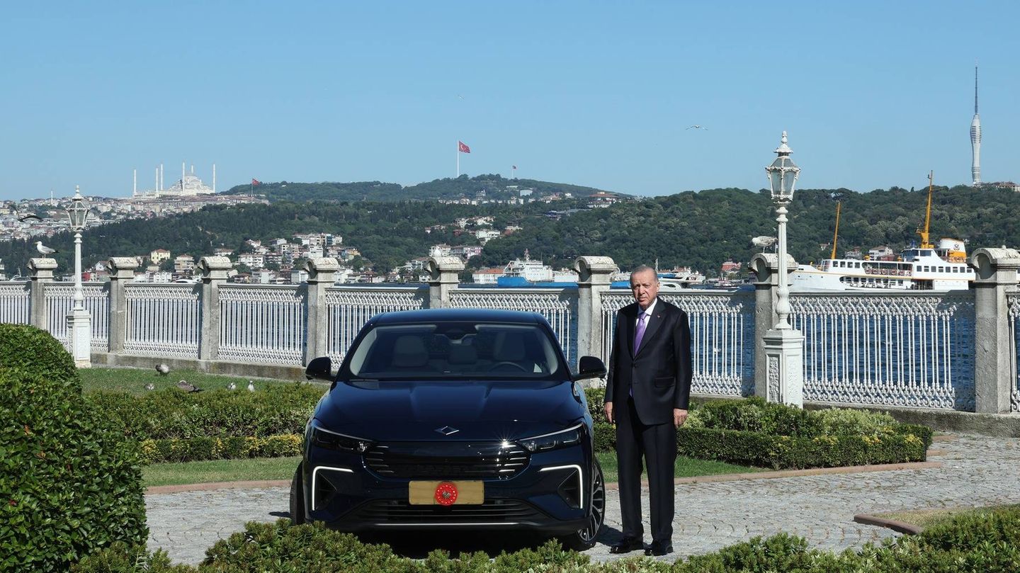 Der türkische Präsident Erdogan steht neben einem Auto von Togg Der türkische Präsident Erdogan steht neben einem Auto von Togg