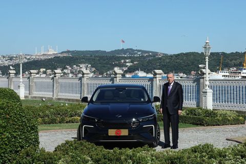 Der türkische Präsident Erdogan steht neben einem Auto von Togg