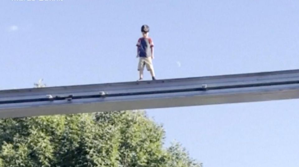 Junge läuft über Achterbahn-Schiene in Pennsylvania Ein junger Junge steht auf den Schienen einer Achterbahn im Freizeitpark.