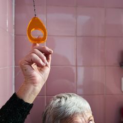 Inkontinenzbehandlungen: Ältere Dame betätigt die Toilettenspülung