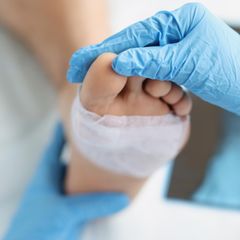 Fußchirurgie: Arzt untersucht Fuß eines Patienten