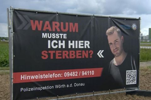 Ein Plakat am Straßenrand mit einem jungen Mann und den Worten "Warum musste ich hier sterben?"