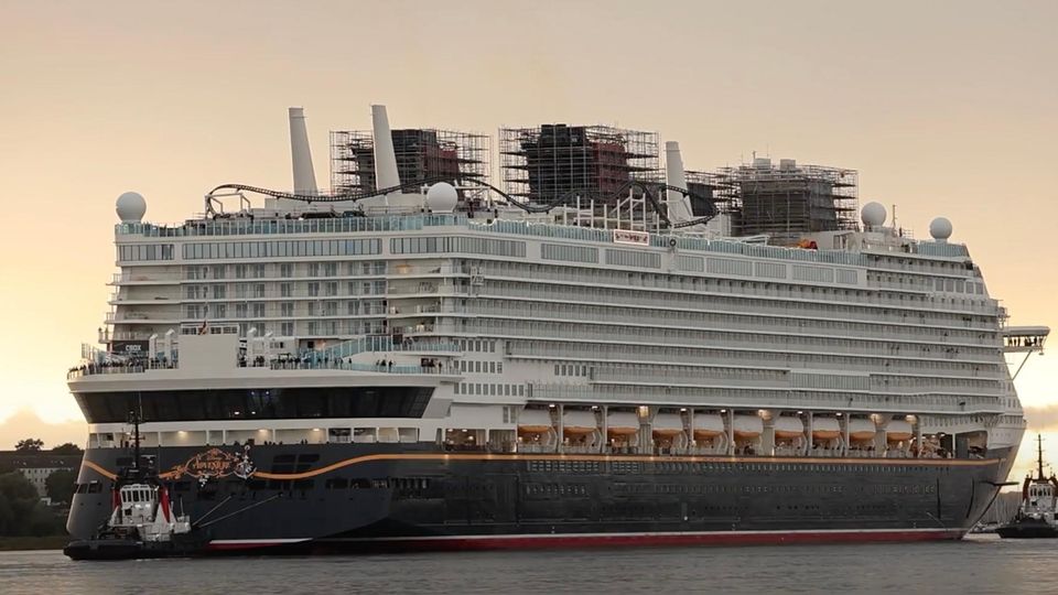 Disney Adventure Ein riesiges Kreuzfahrtschiff auf dem Wasser, der Himmel orange-gelb.