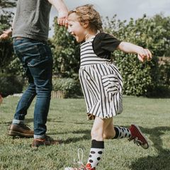 Ein Vater spielt mit seinen Kindern im Garten