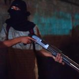 Junger Mann mit Sturmhaube und Schrotflinte