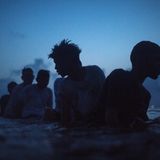 Fünf Jungs schwimmen abends im Meer