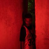 Junge steht in einer Mauerspalte