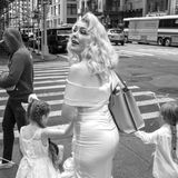 Eine blonde Frau im Marilyn-Monroe-Style mit zwei Töchtern an den Händen