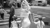 Eine blonde Frau im Marilyn-Monroe-Style mit zwei Töchtern an den Händen