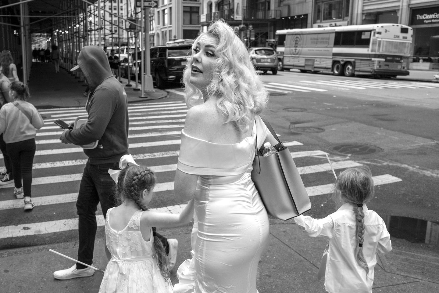Eine blonde Frau im Marilyn-Monroe-Style mit zwei Töchtern an den Händen