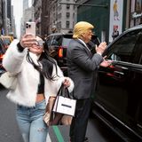 Vor dem Trump Tower posiert ein Mann als Donald Trump und eine junge Frau macht ein Selfie mit ihm