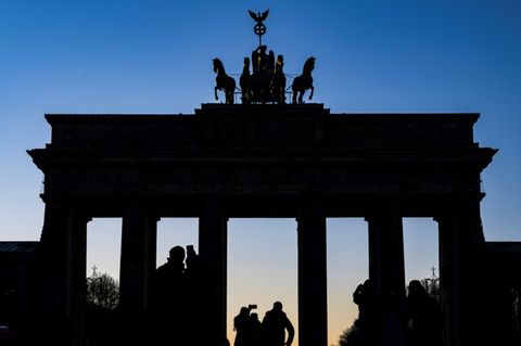 Menschen machen Selfies vor dem Brandenburger Tor