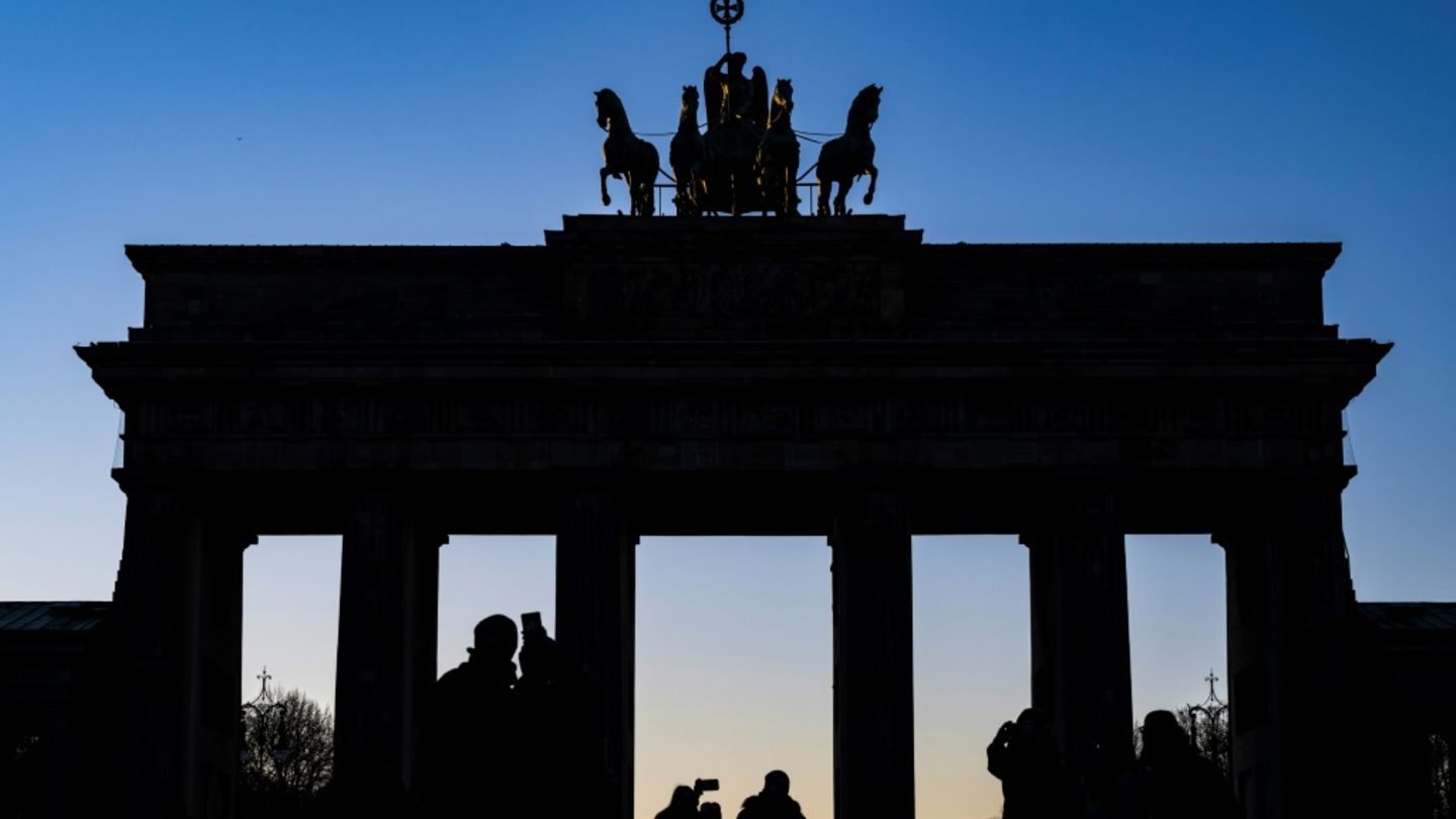 Menschen machen Selfies vor dem Brandenburger Tor