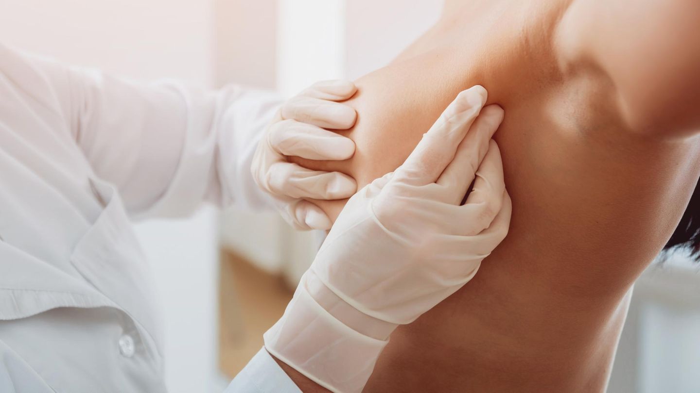 Brustdiagnostik: Arzt tastet die Brust einer Patientin ab.