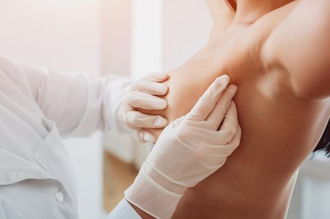 Brustdiagnostik: Arzt tastet die Brust einer Patientin ab.
