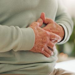 Chronisch Entzündliche Darmerkrankungen: Frau hält die Hände auf den Bauch.