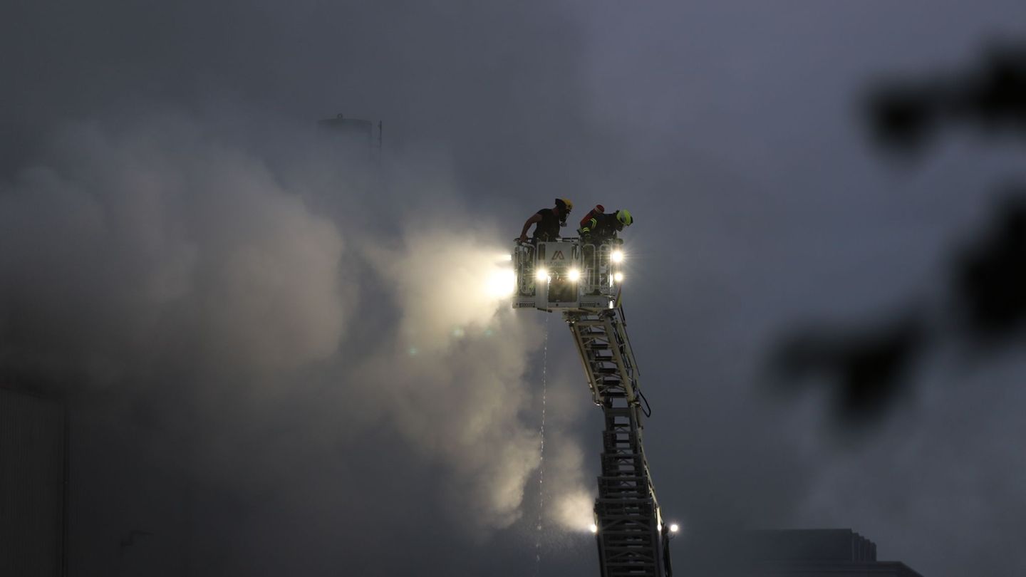 Über eine Drehleiter kämpfen Feuerwehrleute an der Sperrmüll-Halle gegen den Brand. Foto: Sascha Thelen/dpa