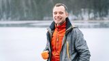 Ein Wanderer lächelt mit offener Jack in die Kamera