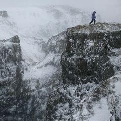 Wanderer in schroffer, schneebedeckter Gebirgslandschaft