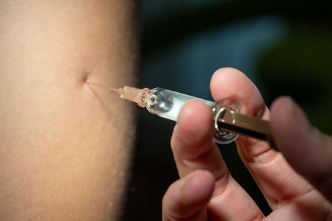 In Florida ist das keinen Pflicht mehr: Eine Spritze wird für eine Impfung in einen Arm gepikt