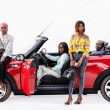 Vier Menschen auf und in einem Mini Cooper