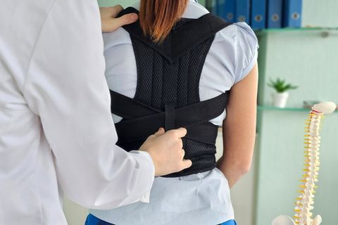 Haltungstrainer: Arzt passt Haltungstrainer bei Patientin an