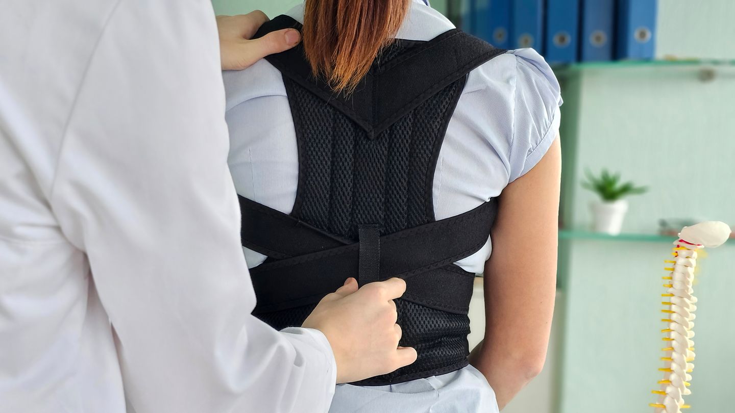 Haltungstrainer: Arzt passt Haltungstrainer bei Patientin an