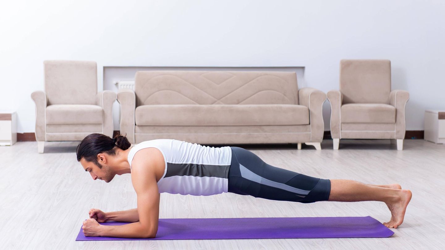 Ein Mann auf einer Yoga-Matte trainiert