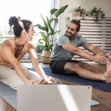 ein Mann und eine Frau dehnen ihre Beine im Sitzen