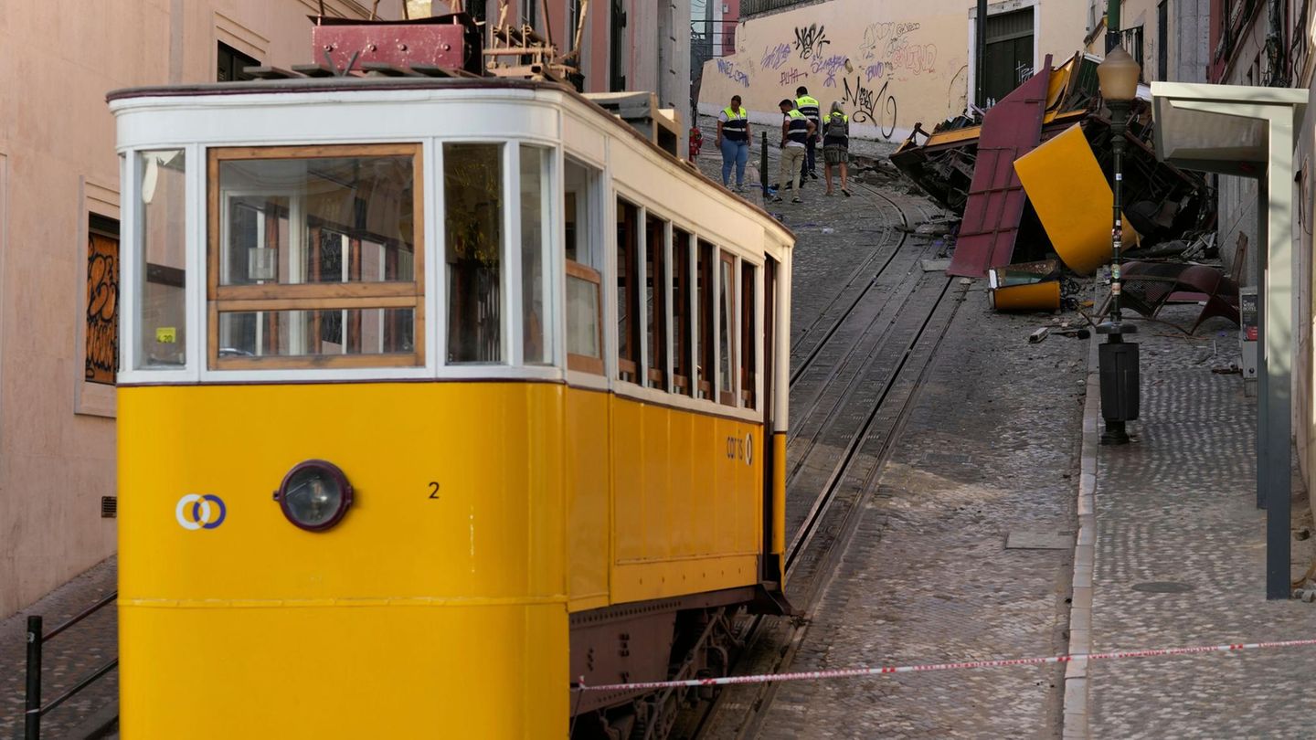 Ein gelb-weißer Waggon der Standseilbahn Lissabon steht unterhalb der Unglücksstelle
