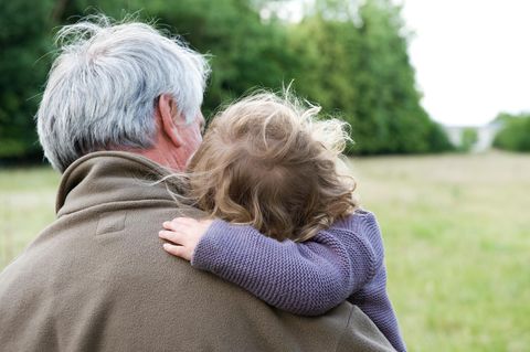 Großvater mit Kind auf einer Wiese