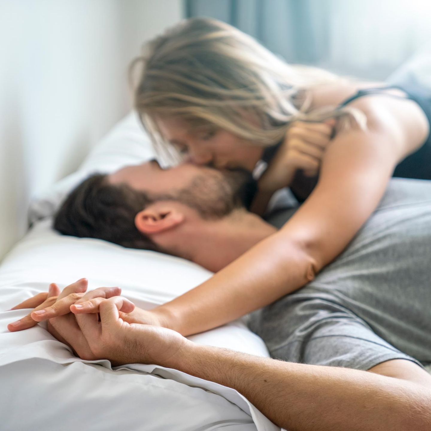 Ein Liebespaar knutscht im Bett (Symbolbild Affäre)
