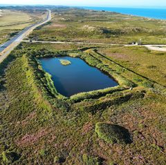 Das auf Sylt angebotene Grundstück umfasst den rechteckigen See und dessen Umgebung