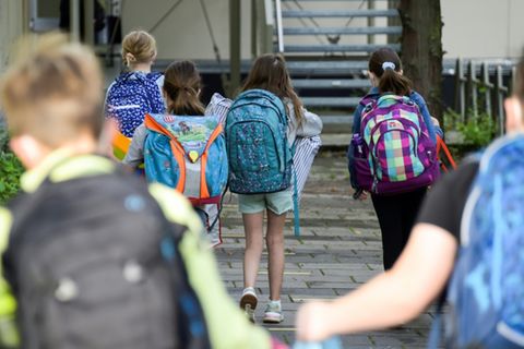 Grundschulkinder vor einer Schule