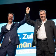 Hendrik Wüst und Markus Söder Hand in Hand auf einer Bühne