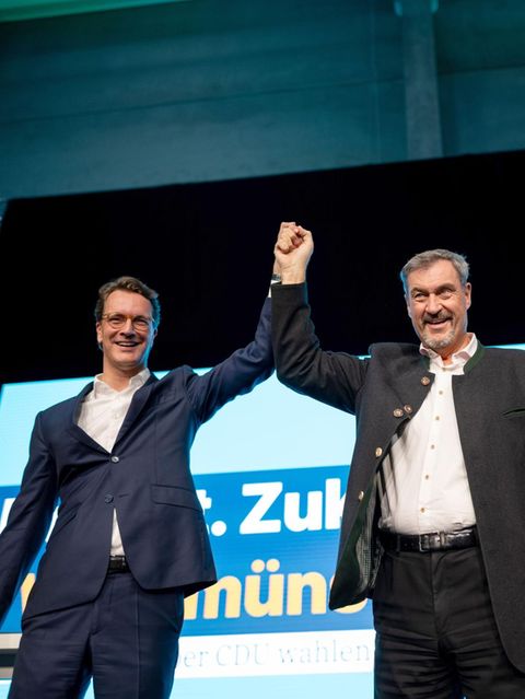Hendrik Wüst und Markus Söder Hand in Hand auf einer Bühne
