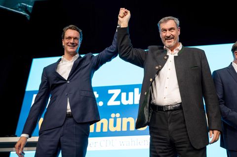Hendrik Wüst und Markus Söder Hand in Hand auf einer Bühne