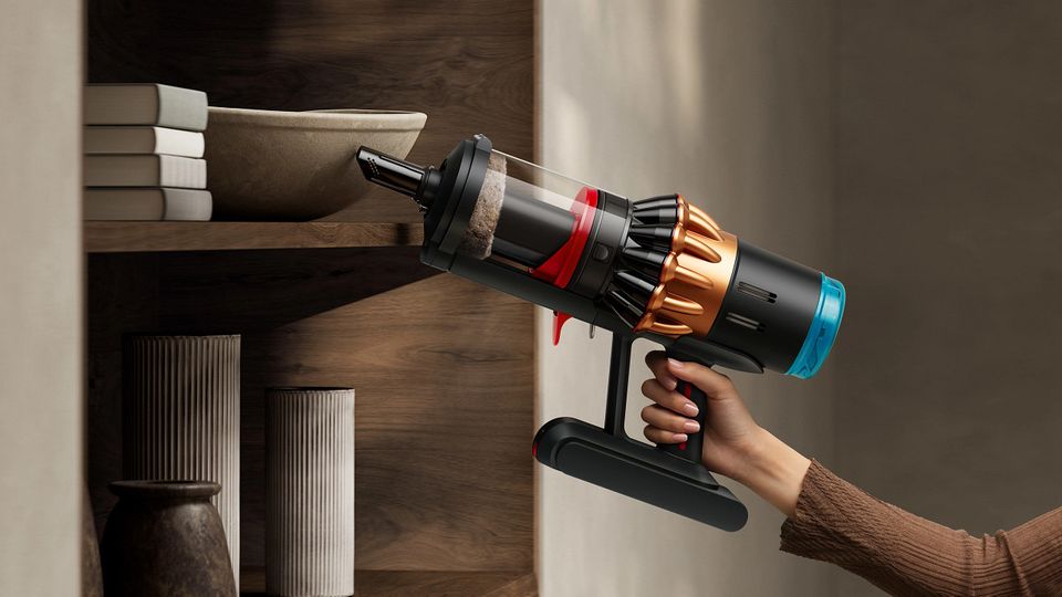 Der Dyson V16 wird benutzt, um ein Buchregal abzusaugen Der Dyson V16 wird benutzt, um ein Buchregal abzusaugen