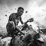 Fotografie: Ein Mann, der mit Schwärmen von Fliegen um Essensreste