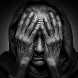 Schwarz-Weiß: eine ältere indische Frau verbirgt ihr Gesicht in ihren Händen