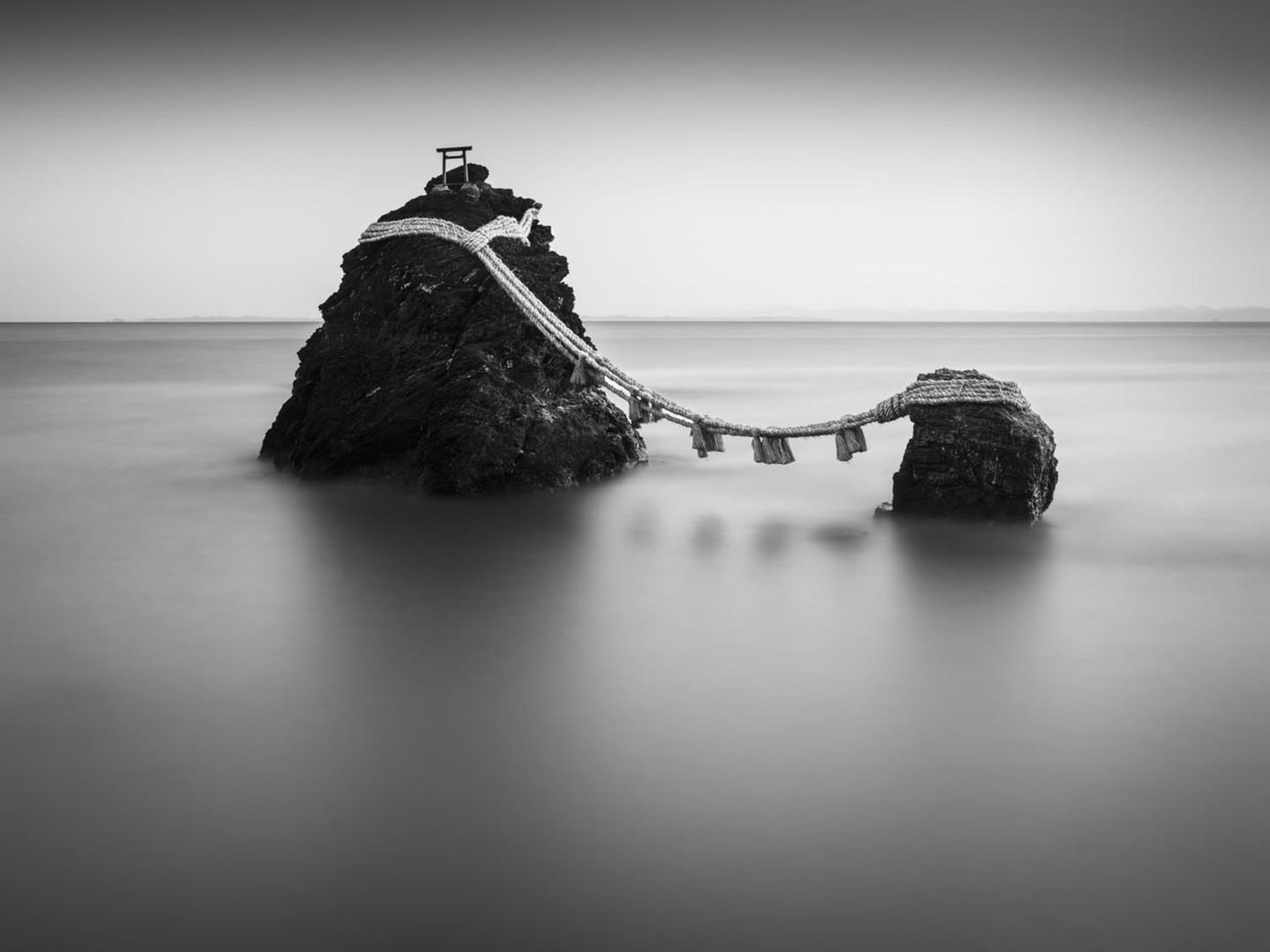 Fotografie: zwei Felsen vor Japans Küste, durch eine Seilbrücke verbunden