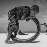 Fotografie: ein Kind beugt sich über einen Reifen, sein Körper scheint mit dem Reifen zu verschmelzen