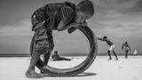 Fotografie: ein Kind beugt sich über einen Reifen, sein Körper scheint mit dem Reifen zu verschmelzen