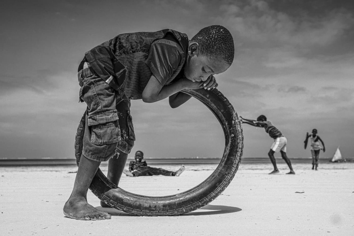 Fotografie: ein Kind beugt sich über einen Reifen, sein Körper scheint mit dem Reifen zu verschmelzen