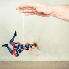 Illustration Narzissmus : Frau hängt an einer Schnur und wird von einer Hand hochgehalten